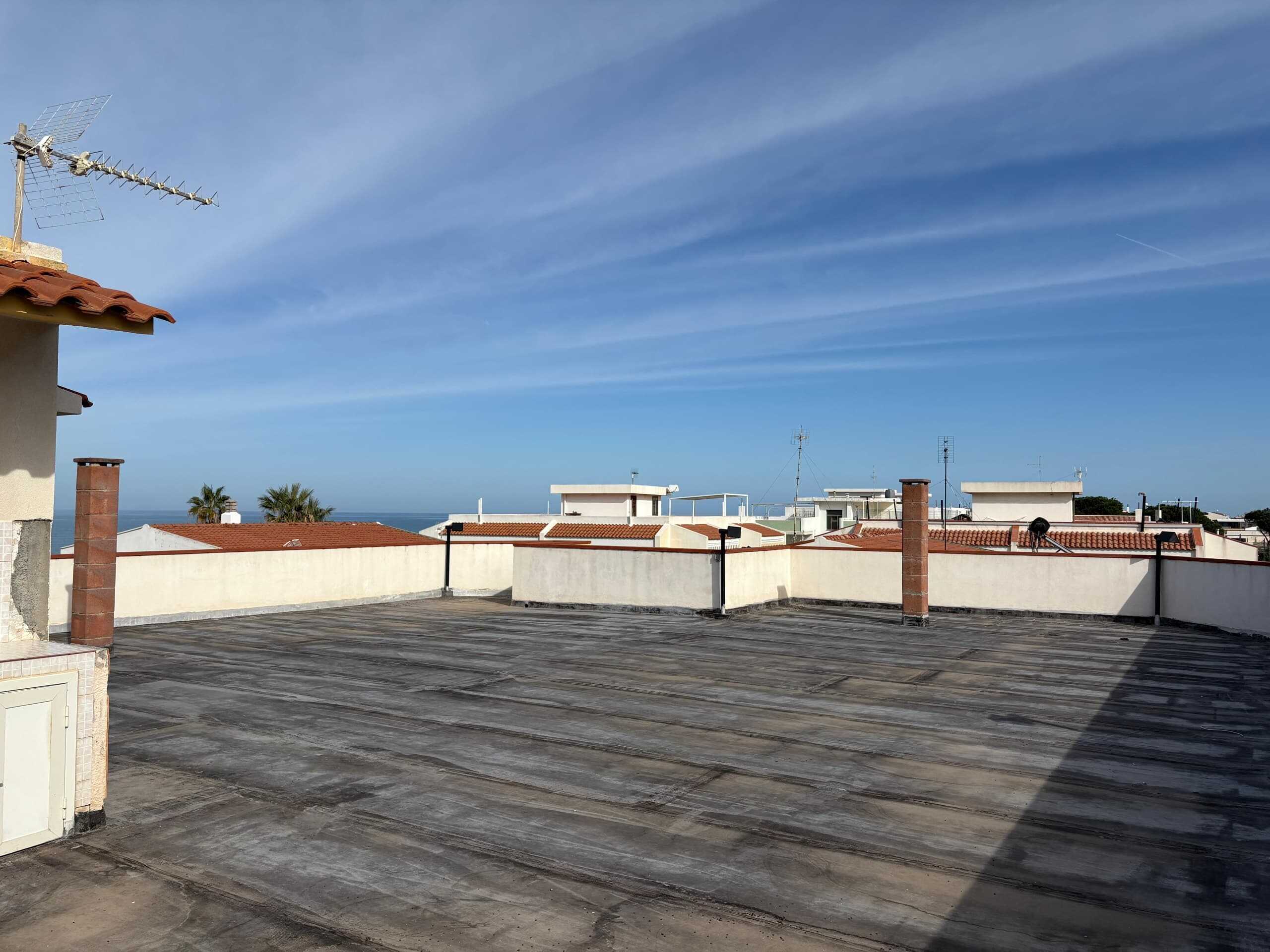 Tetto panoramico di appartamento con vista mare, area coperta e in parte scoperta, tetti in terracotta e camino, ottima soluzione di immobili residenziali con vista mare.