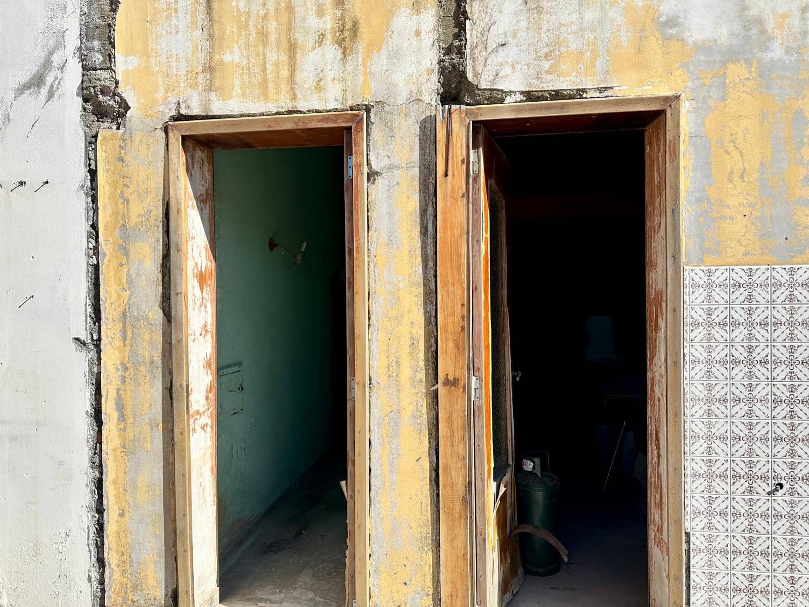 Finestre in fase di ristrutturazione su edificio storico, lavori in corso per intervento di recupero edilizio e ristrutturazione della facciata, dettagli di lavori di restauro e manutenzione edilizia sul progetto NextCasa.