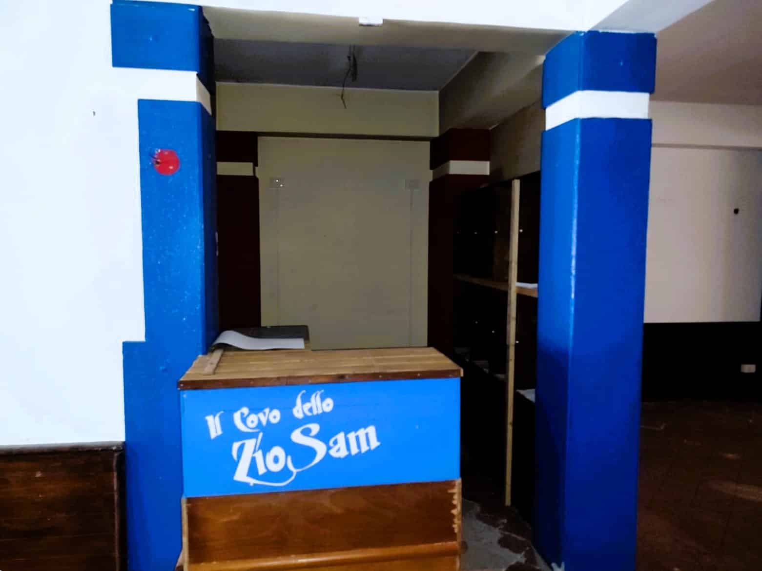 Modulo vendita in costruzione con struttura in legno e pannelli blu, area reception con insegna "Il cuore dello Zio Sam" per attività di ristorazione o vendita.