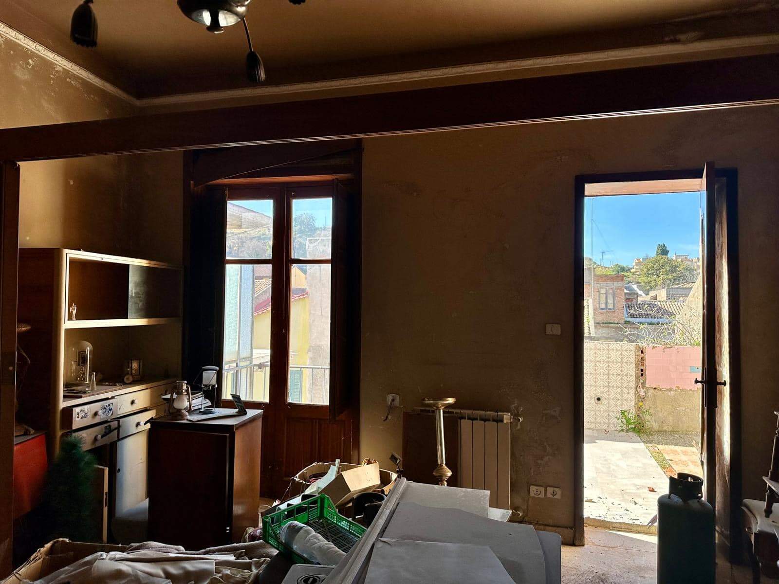 Rustico in ristrutturazione, interni abitabili con finestre e porte in legno, rivolta verso l'esterno, ambienti spaziosi e luminosi ideali per creare una casa accogliente.