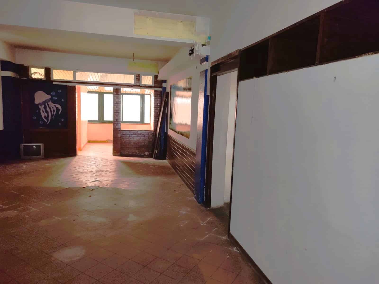 Veranda in fase di ristrutturazione con pareti in mattoni rossi, ampie finestre, pavimento in piastrelle di terracotta, spazi aperti e luce naturale, ideale per progetti di ristrutturazione e decorazione.