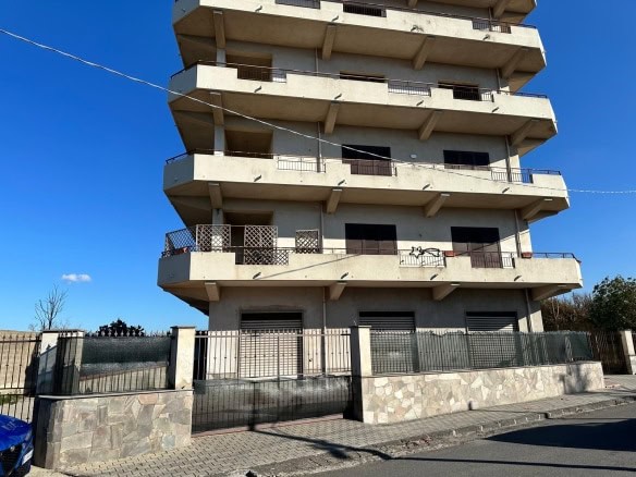 Immobile residenziale multifamiliare con ampie terrazze e balconi, costruzione moderna in cemento armato, situato in zona urbana soleggiata e a pochi minuti dal centro città.