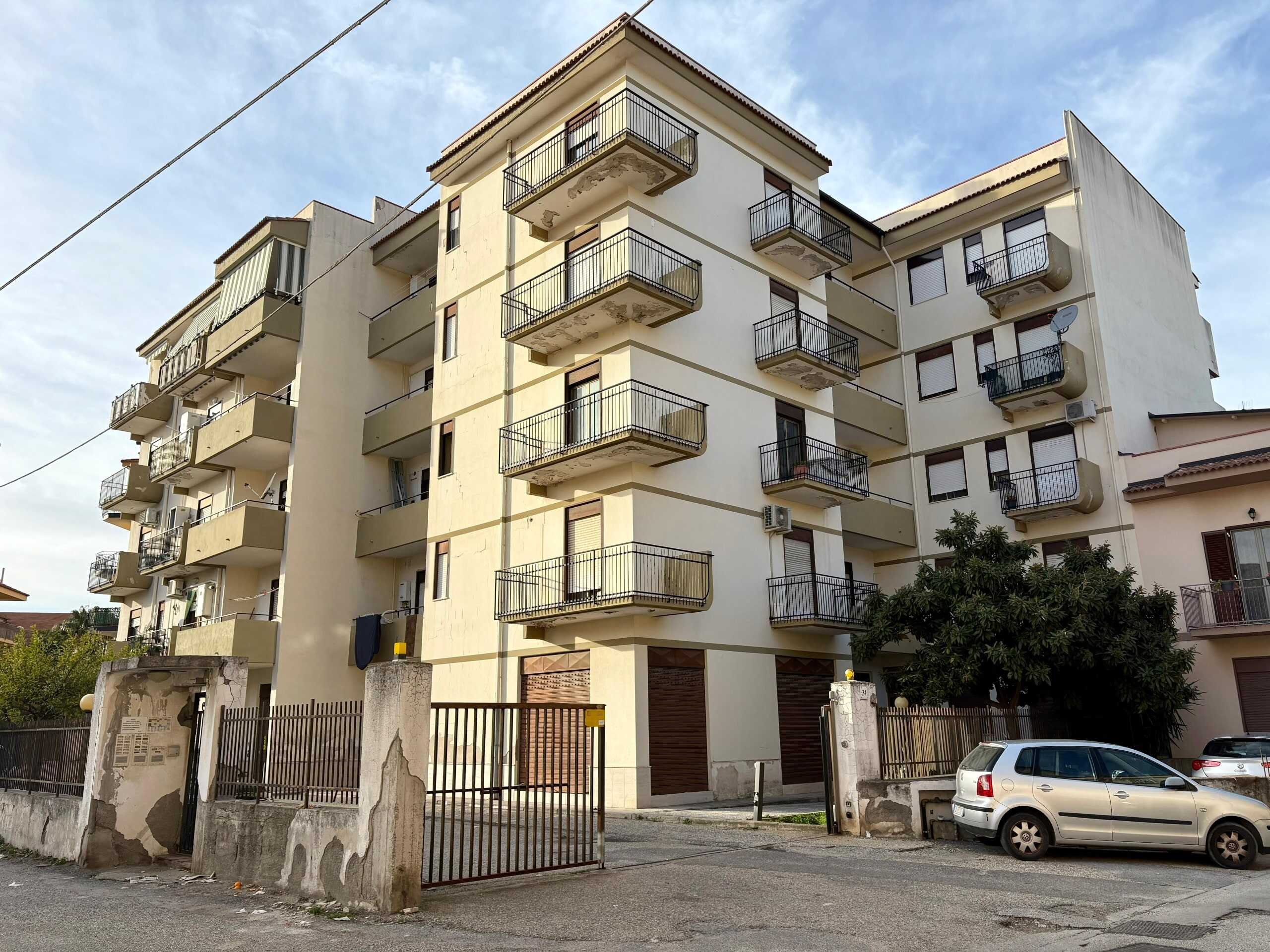 Appartamenti con balconi spaziosi in edificio residenziale a Roma, facciata bianca, spazi condominiali, parcheggi auto, zona urbana tranquilla, ideale per investimenti immobiliari e vita quotidiana.