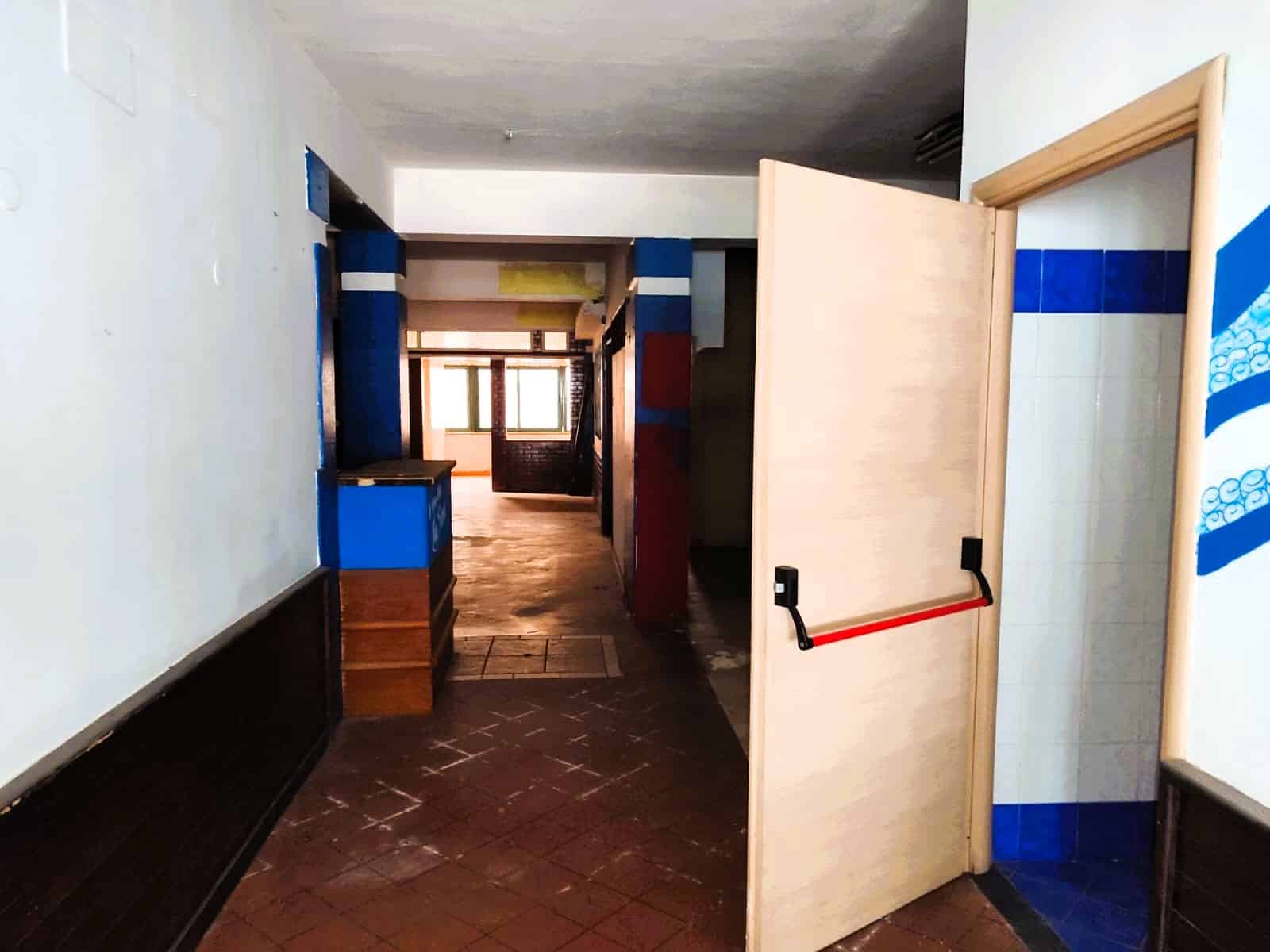 Porta di accesso a un appartamento con pareti dai colori vivaci e finiture in ceramica, ambienti interni spaziosi e luminosi, ideale per residenze moderne e accoglienti.