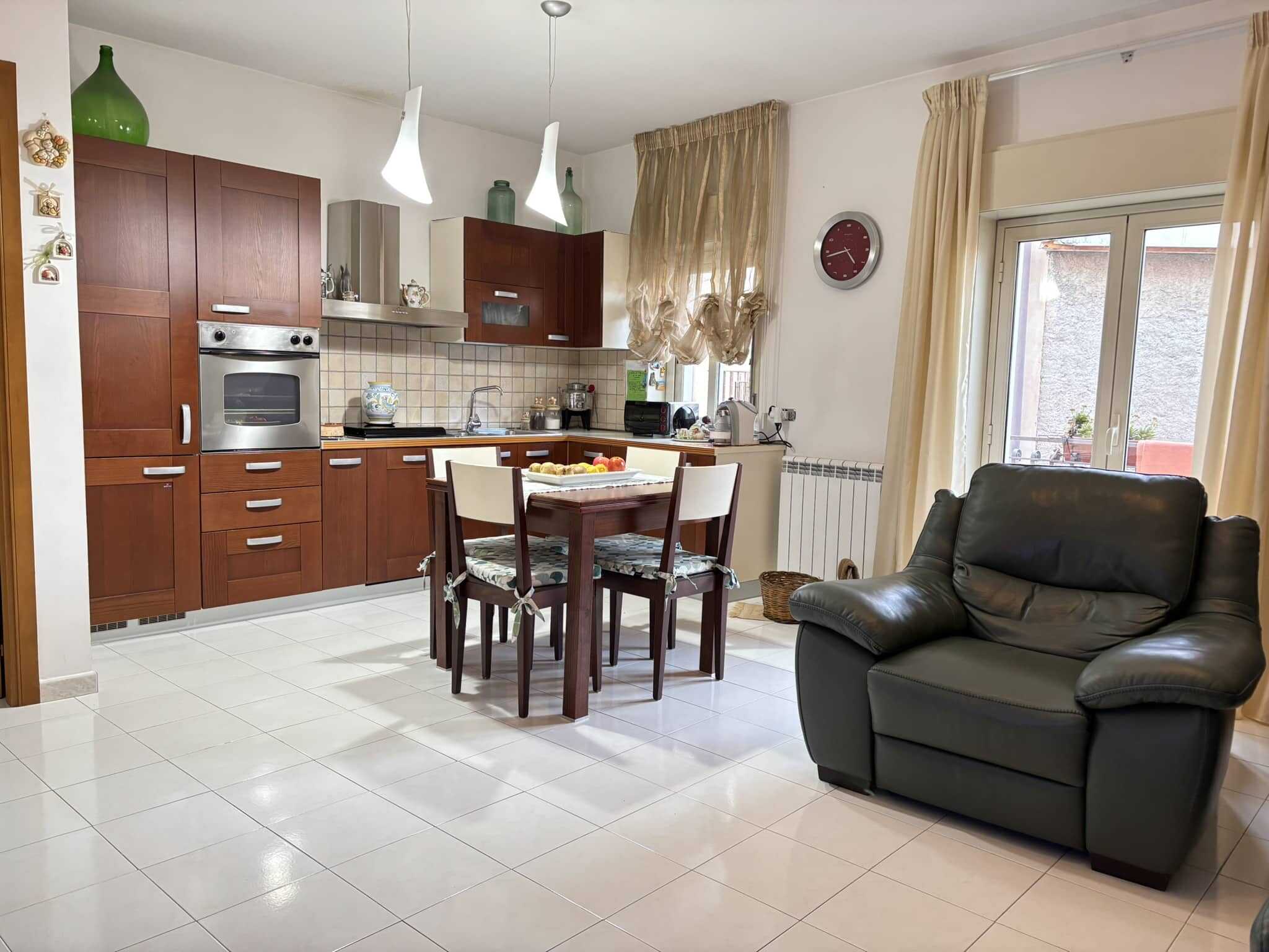 1 Ulteriori dettagli: Cucina abitabile con mobili in legno, zona pranzo e soggiorno con divano in pelle, esposizione luminosa con grandi finestre, arredamento accogliente e elementi decorativi in stile classico.