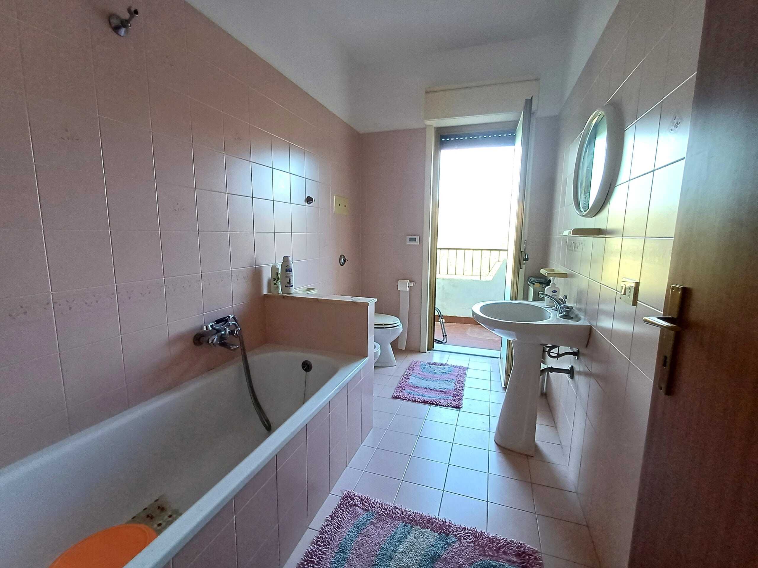 Lavabo, bidet e vasca da bagno con accesso a balcone, bagno spazioso in appartamento in vendita a NextCasa, soluzione ideale per famiglie o investimento immobiliare.