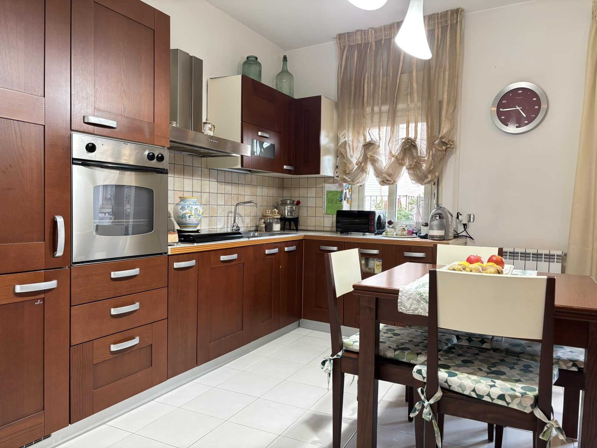 Alta qualità di cucinino con armadi in legno scuro, elettrodomestici moderni e ambiente luminoso, ideale per case famigliare.