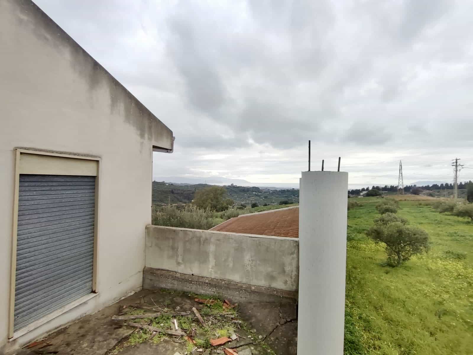 Balcone di edificio in fase di ristrutturazione con vista sulla campagna, cielo nuvoloso, ambiente rurale, open space, spazio esterno, tranquillità e paesaggi naturali, immobili con potenzialità.