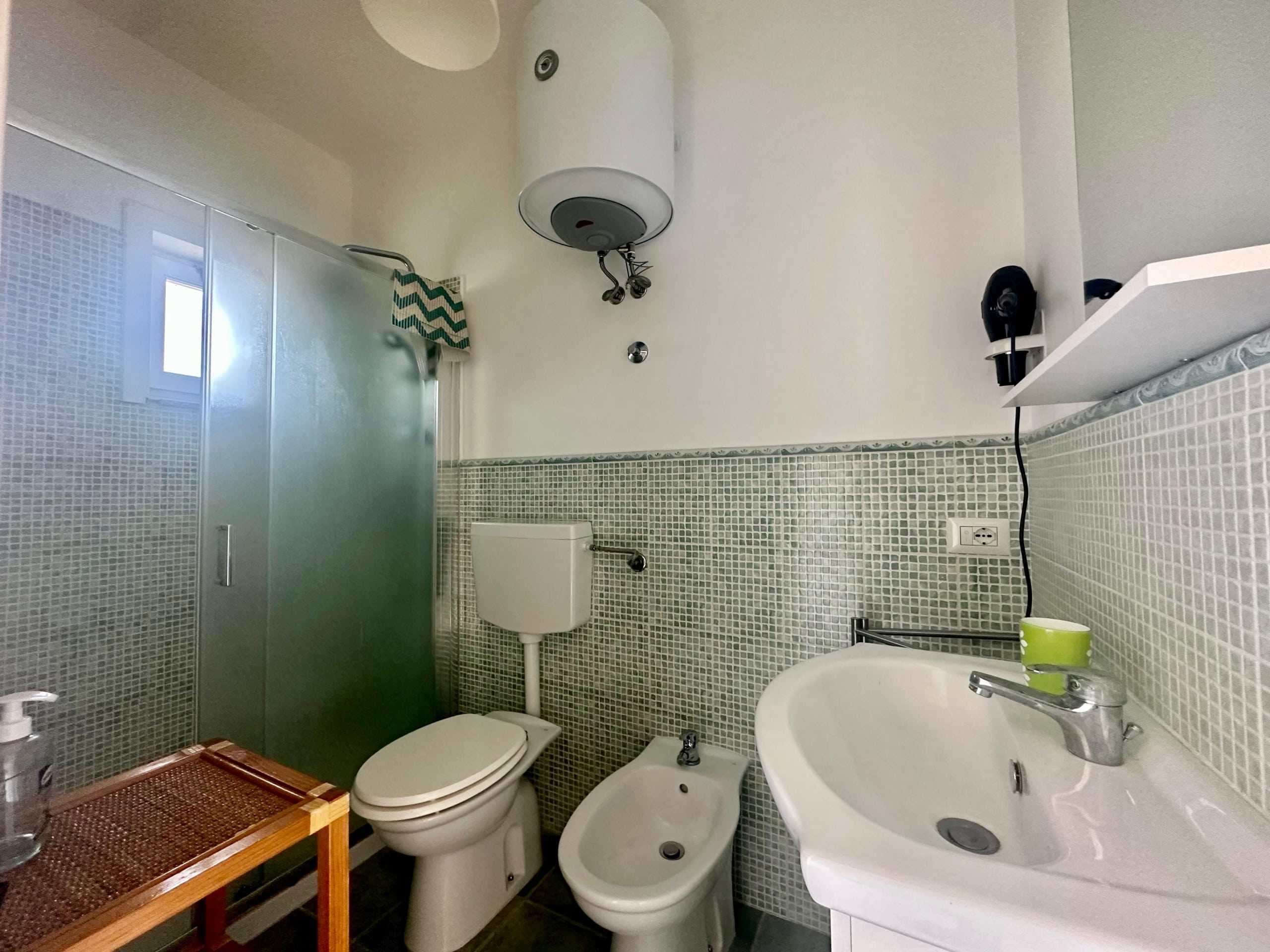 Doccia con parete in vetro in bagno, sanitari bianchi, lavabo e specchio, minimalista e funzionale. Eccezionale soluzione di arredo bagno moderna, ideale per case e appartamenti a NextCasa.