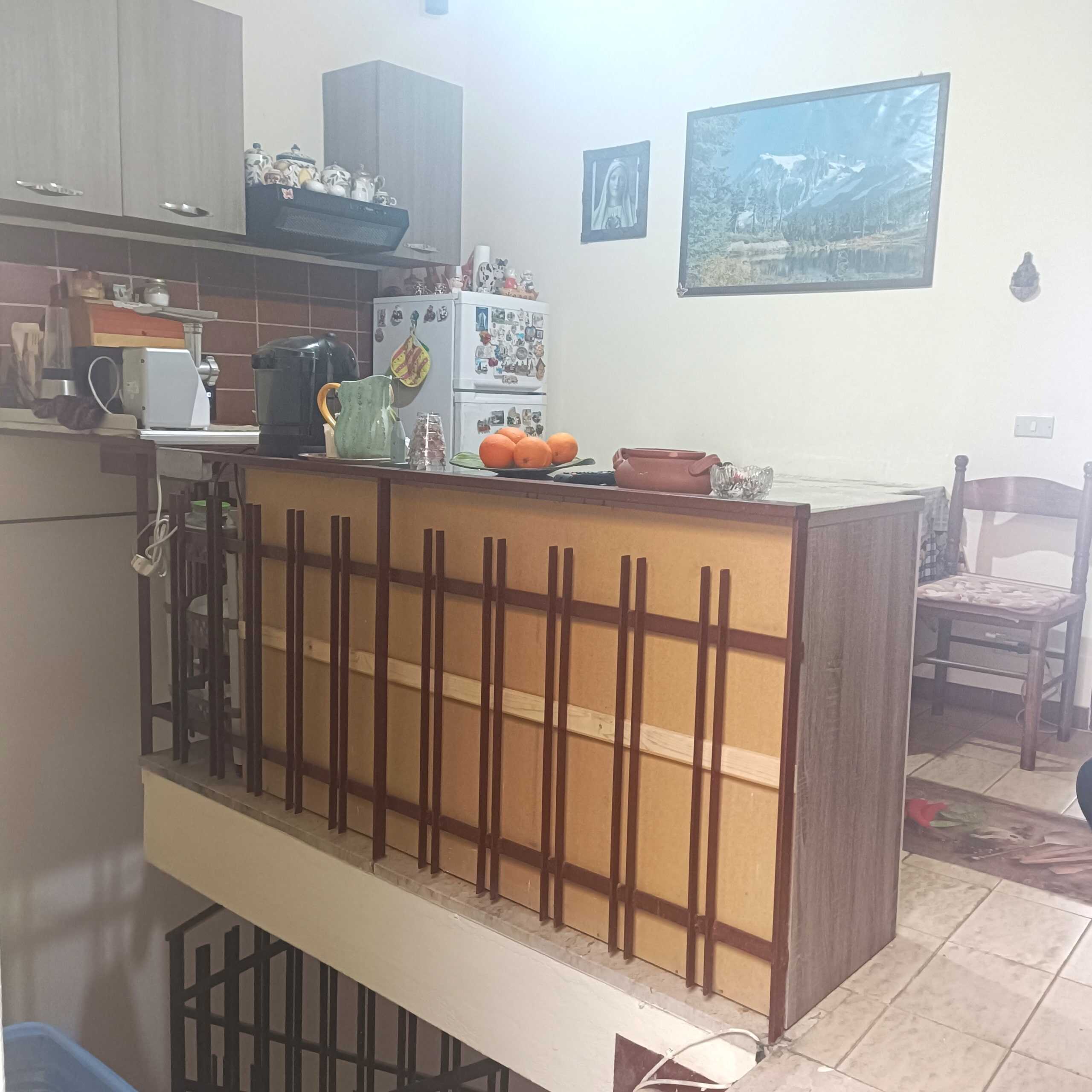 Pompa di cucina con snack e utensili, soggiorno abitabile con pareti decorate e mobili funzionali. Cucina luminosa e accogliente con elettrodomestici e decorazioni casalinghe.
