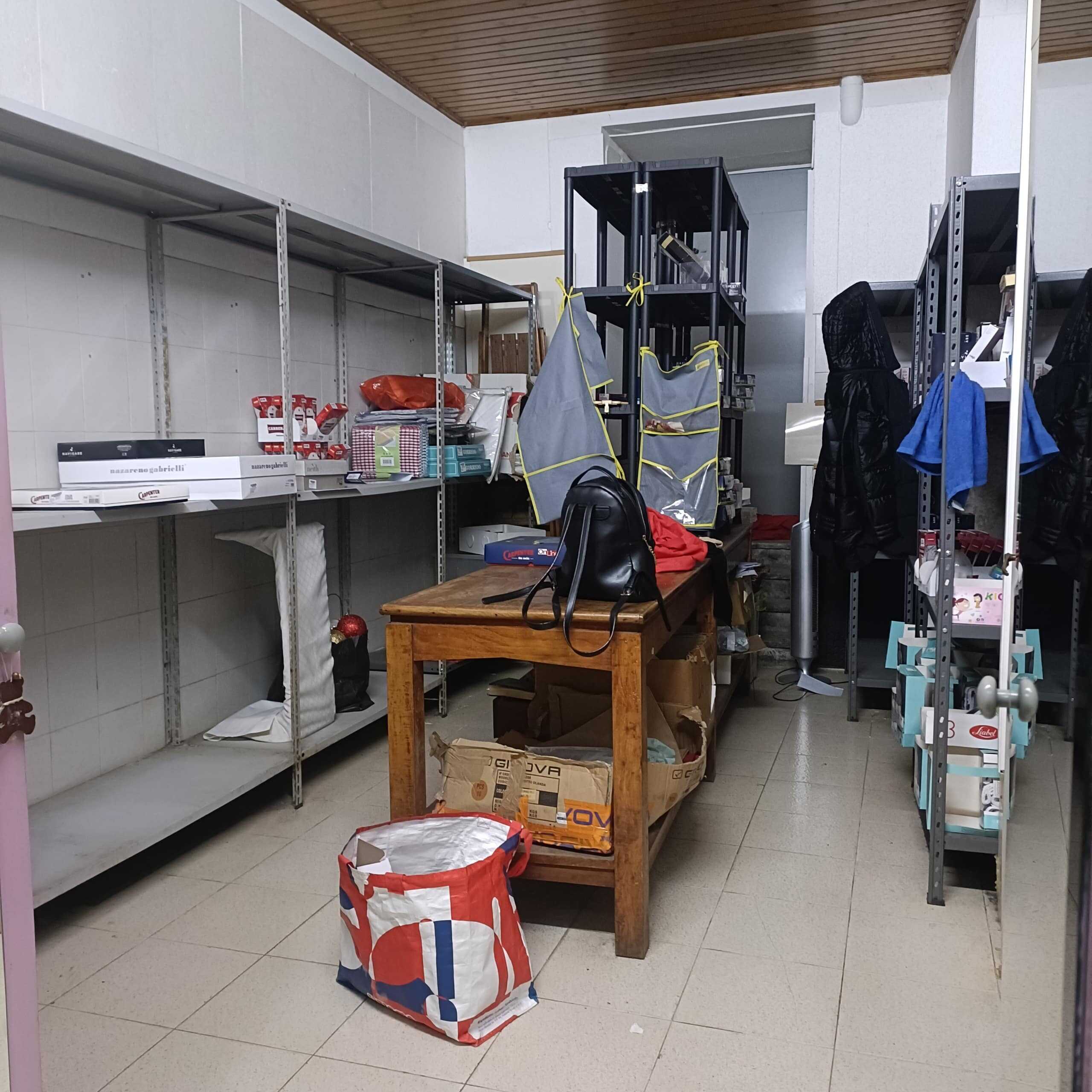 Immagine di un magazzino o deposito con scaffali pieni di scatole e materiali vari, utilizzata come esempio per soluzioni di stoccaggio e organizzazione negli ambienti abitativi con NextCasa.