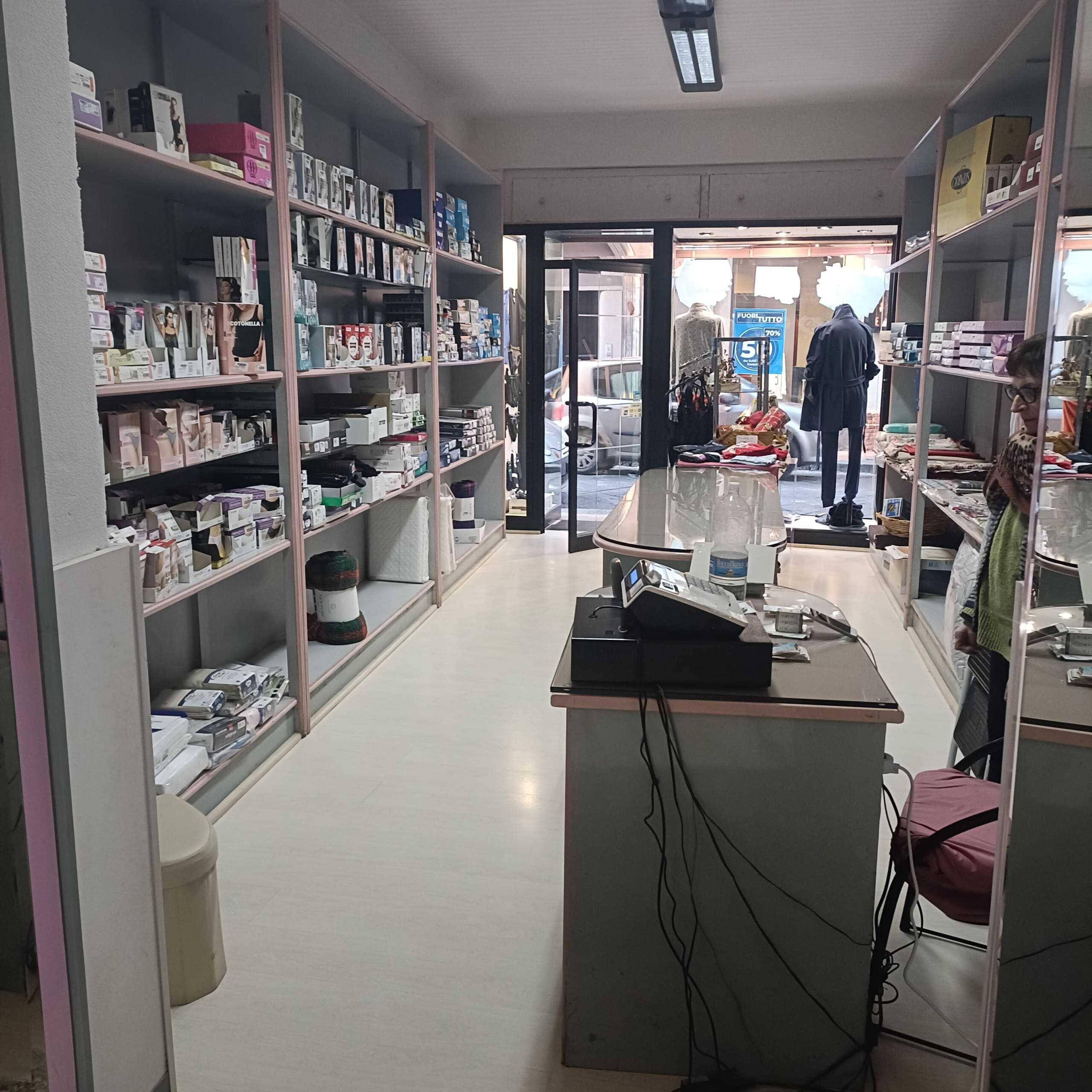 Scaffali con prodotti per la casa e l'arredamento, negozio di dettagli e accessori, interno di negozio con ingresso luminoso e clienti, esposizione di articoli per la casa e il decor, ottimizzato SEO per NextCasa capitale di arredamento.