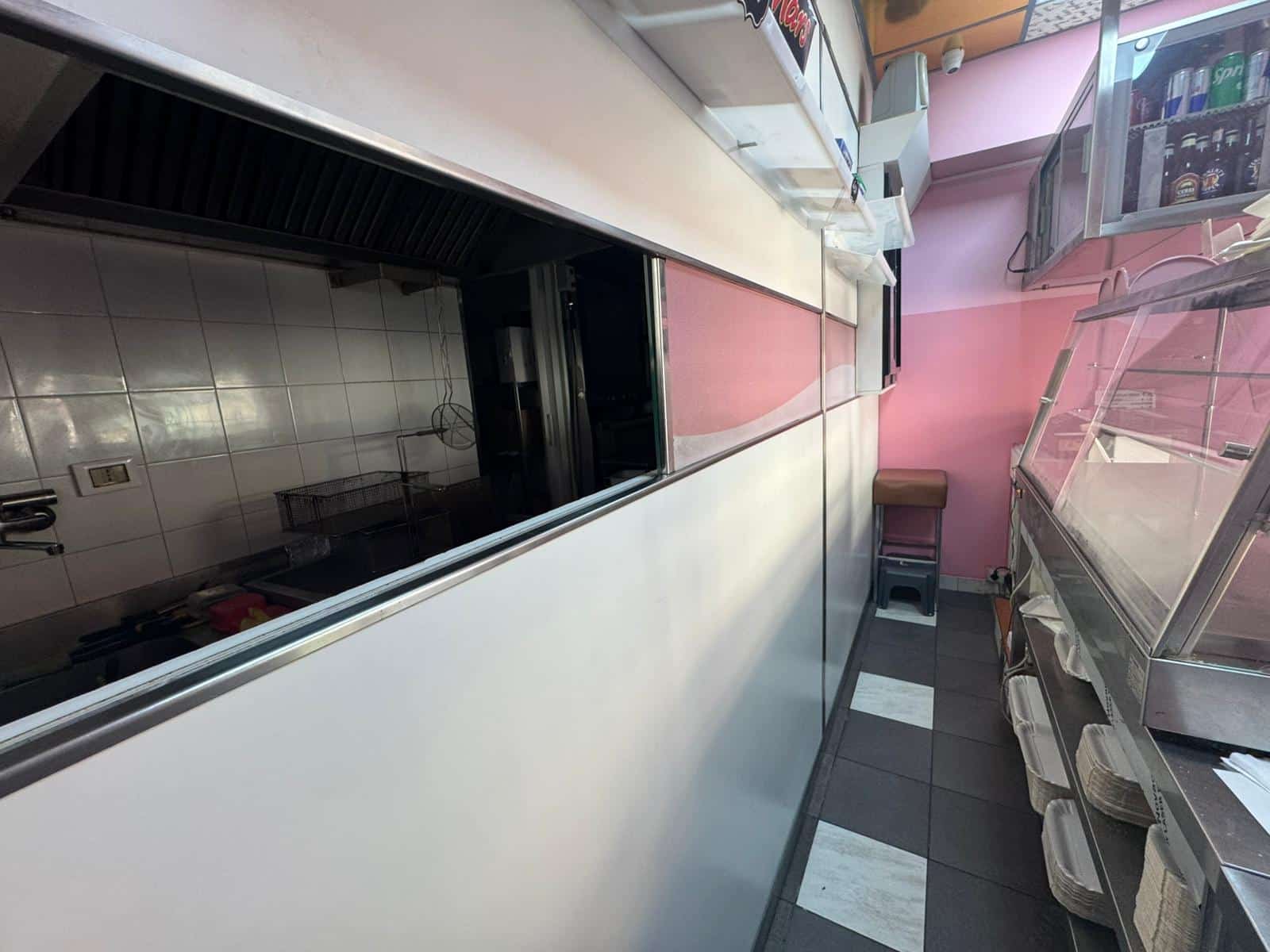 Bancone frigorifero in un negozio di alimentari, attrezzature professionali per la vendita di prodotti alimentari freschi, ambiente commerciale ordinato e funzionale, spazio di lavoro ben organizzato.