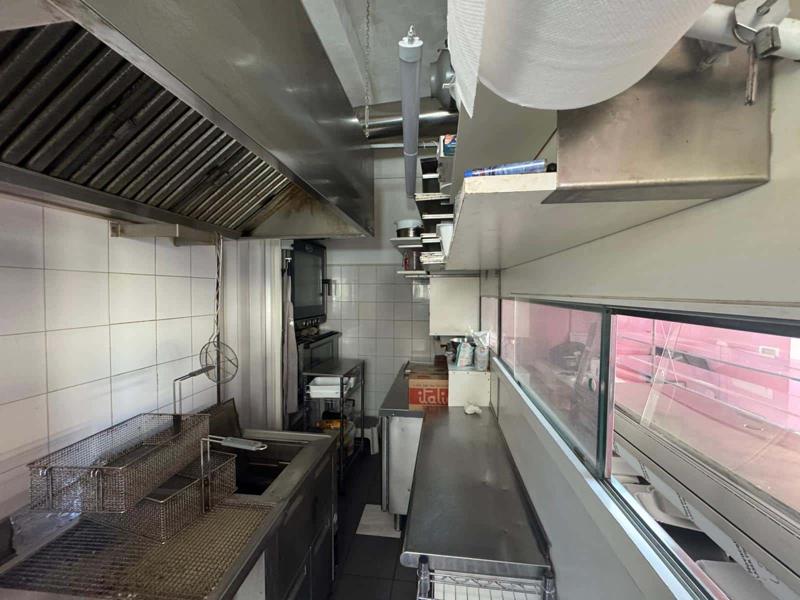 Fornitura di una cucina professionale in stile industriale con area di lavoro in acciaio inox, griglie, piano di lavoro spazioso e attrezzature commerciali, perfetta per ristoranti o cucine di autogeneratedentà.