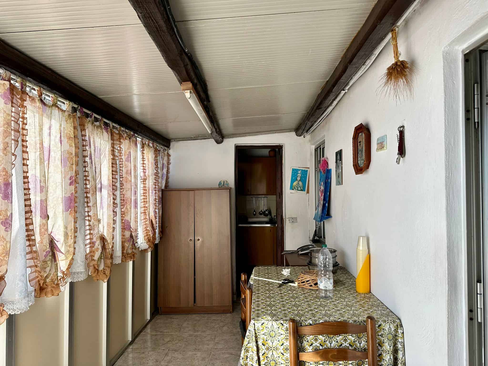 A0. image of a cozy indoor space with floral curtains, wooden furniture, and decorative wall accents in a home setting.