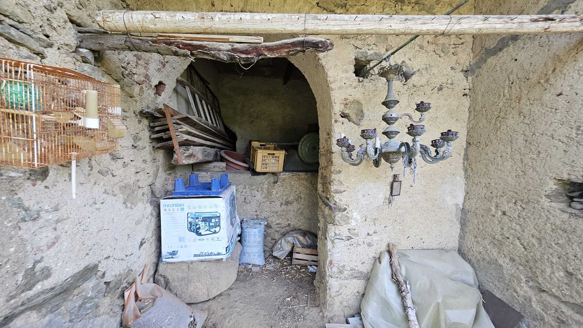 Vecchio spazio rustico con arredi in legno e lampadario in stile vintage, ambiente da ristrutturare con materiali di recupero e decorazioni eccentriche, stile rustico provenzale.