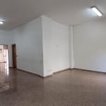 Ampio spazio ufficio o commerciale vuoto con pavimento in marmo, pareti bianche e illuminazione fluorescente, ideale per attività professionali o spazi di coworking.