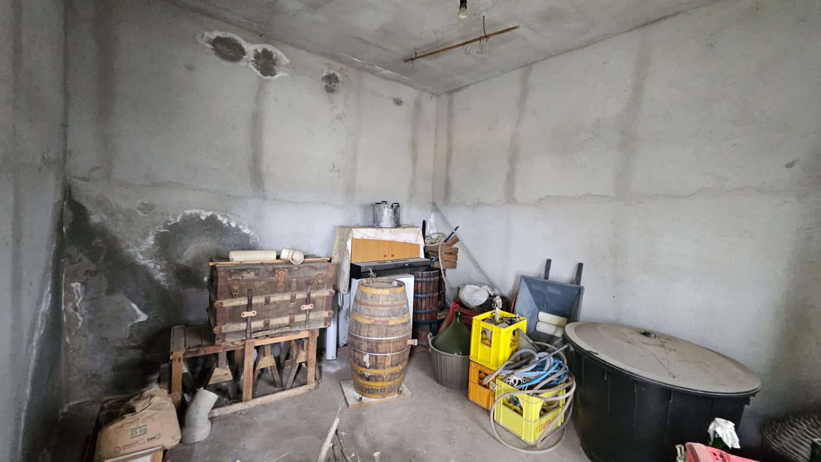 Vecchia soffitta in cassone con varie scatole, barili e oggetti di riciclo, spazio di deposito di una casa in costruzione o ristrutturazione, ambiente semplice e non rifinito.