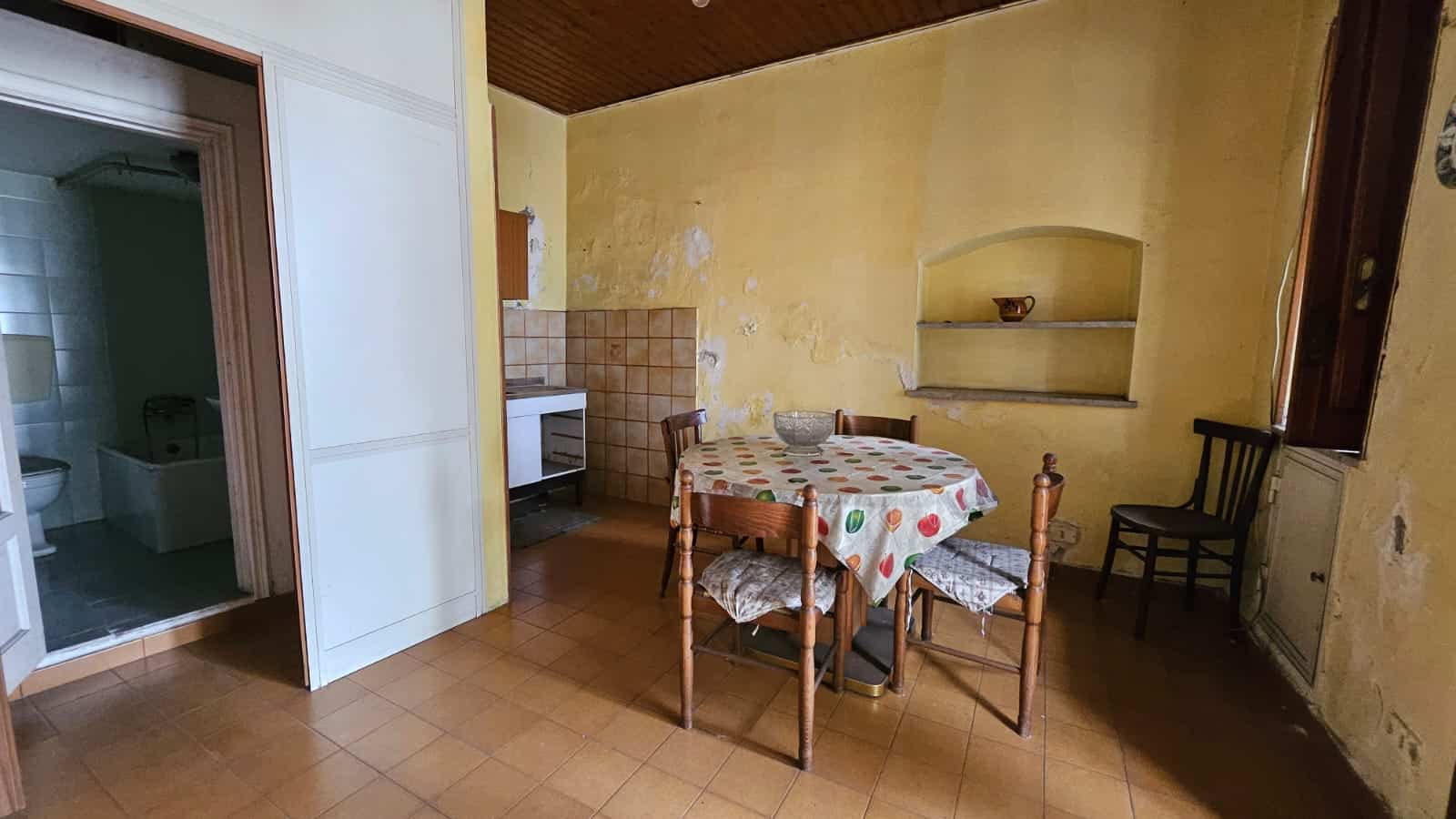 Rustico ristrutturato con cucina in stile tradizionale, pareti gialle e arredi in legno, zona pranzo accogliente, ideale per case di campagna e immobili di charme.