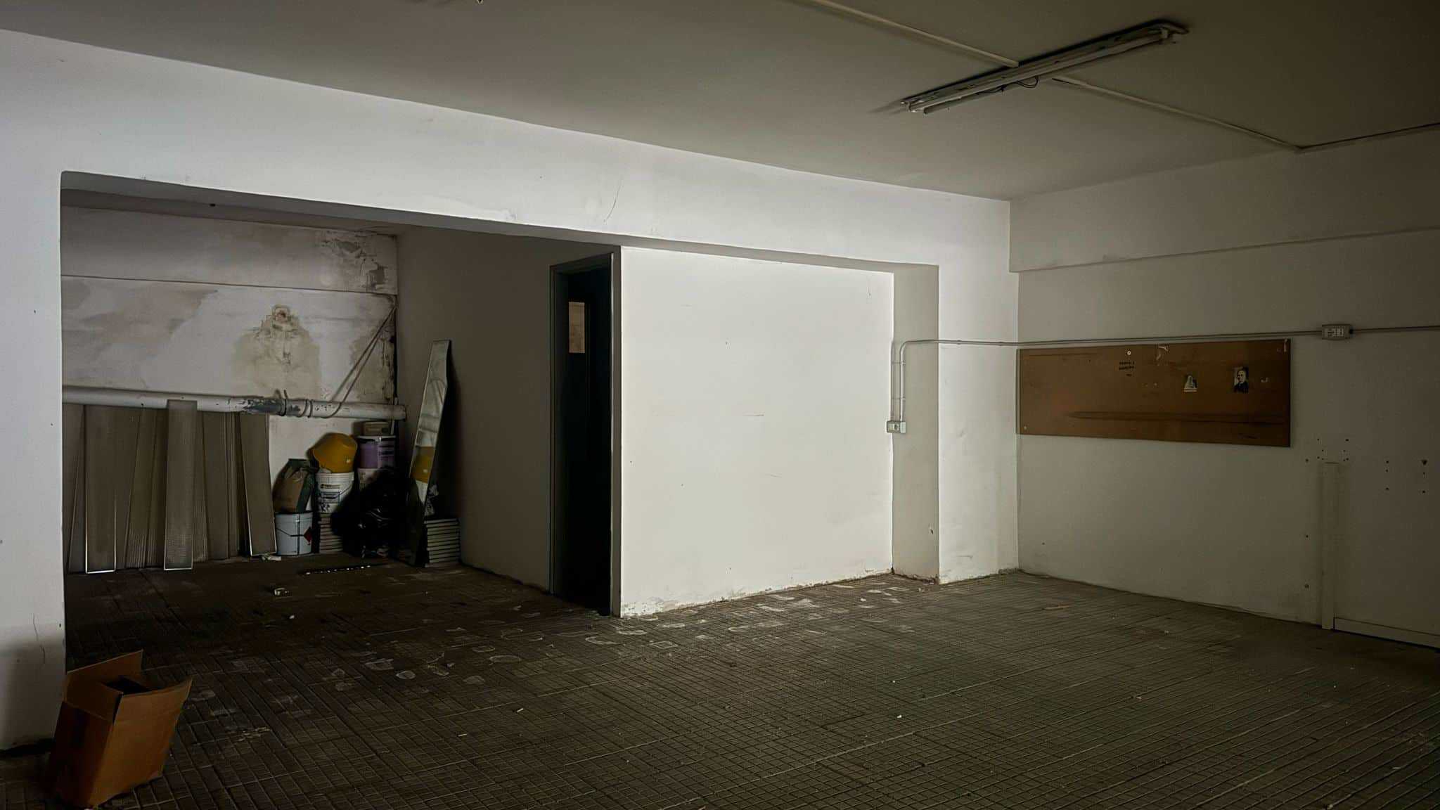 Sgombero garage in fase di ristrutturazione, spazio vuoto con pareti bianche e attrezzi da lavoro, ideale per ristrutturare o riorganizzare ambienti domestici e commerciali.
