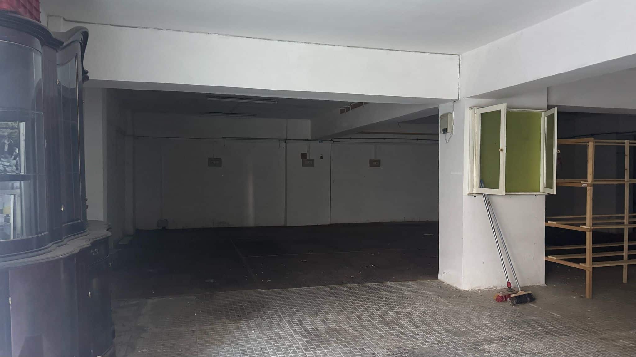 Garage di parcheggio in ambienti commerciali con spazio di archiviazione e scaffali in legno, ideale per esigenze di stoccaggio e organizzazione spaziale presso NextCasa.