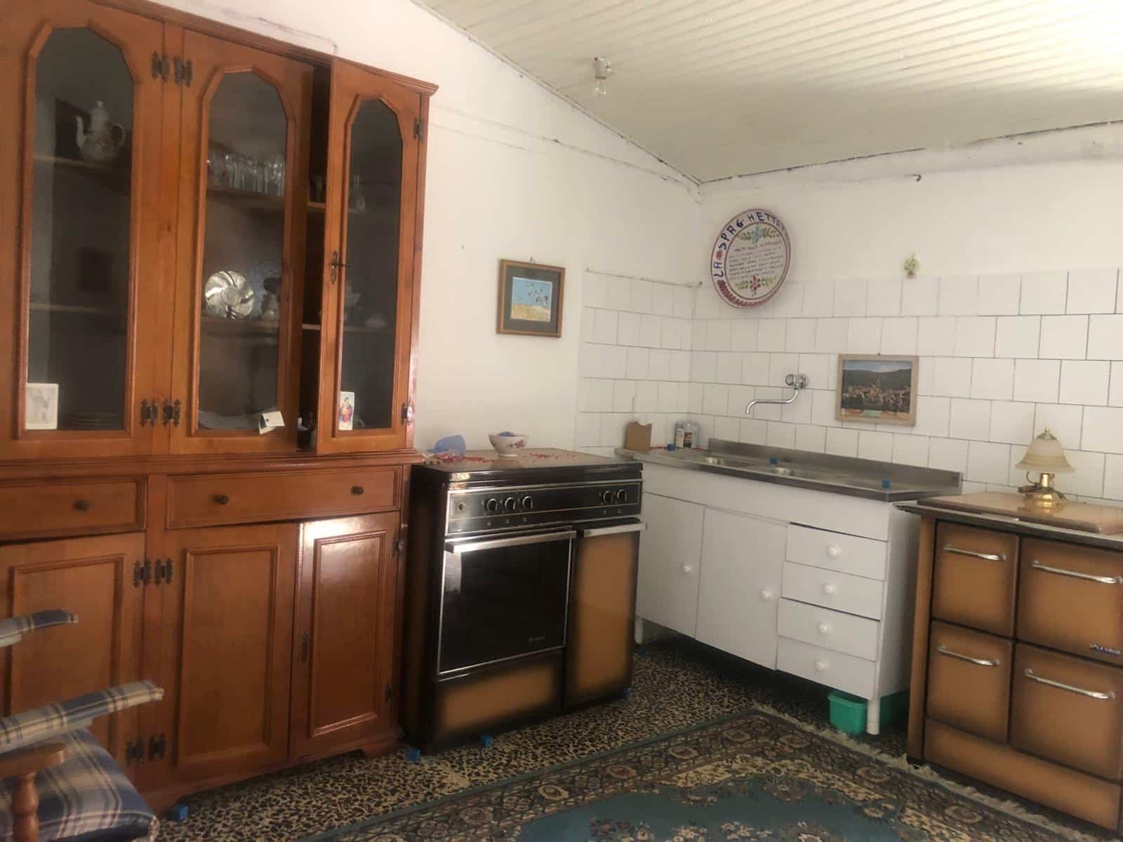 Armadio in legno e cucina vintage con frigorifero nero in una stanza abitabile.