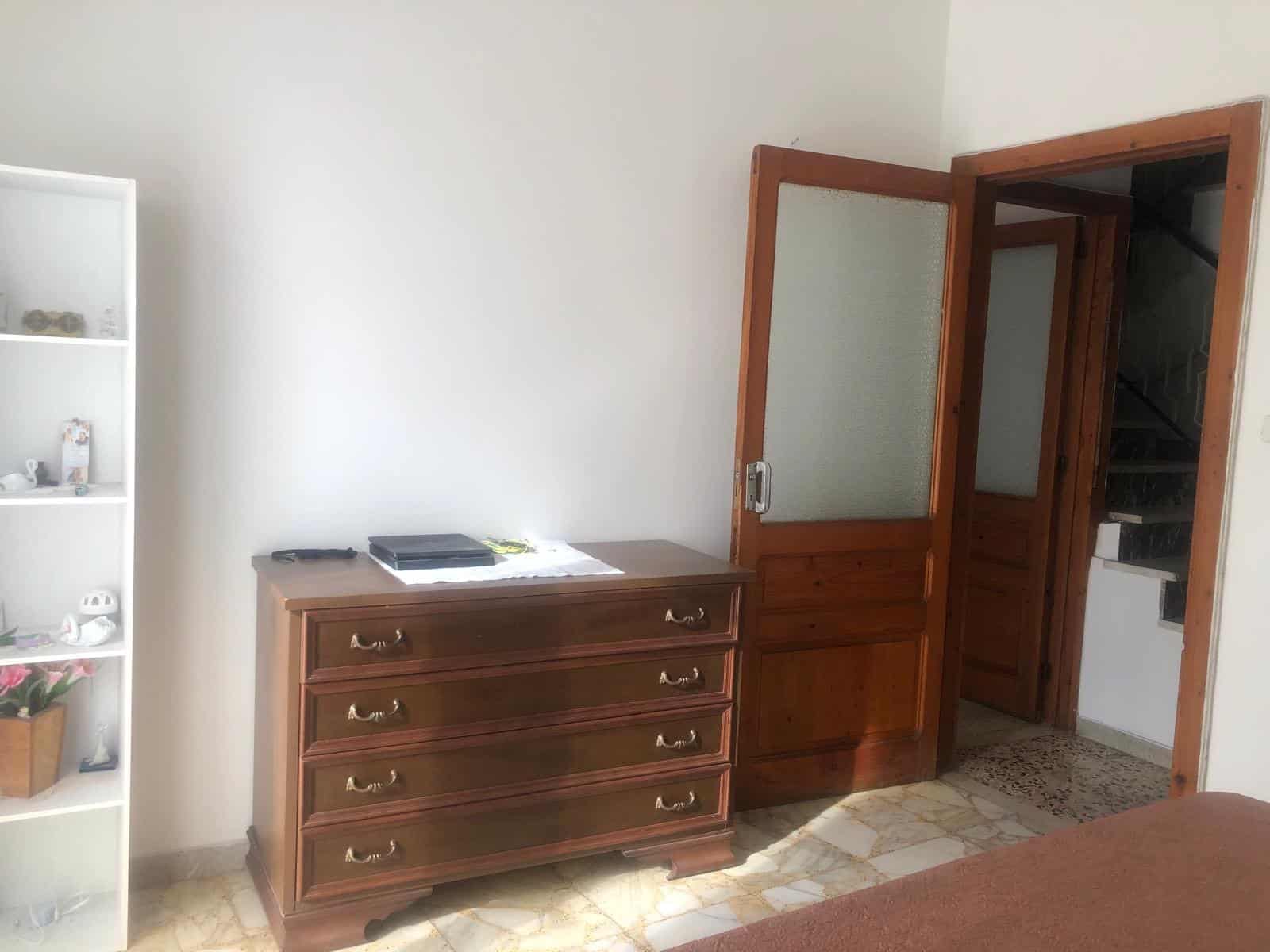 Elegante armadio in legno con quattro cassetti, in un ambiente domestico accogliente, ideale per arredare camere da letto con stile classico e funzionale.