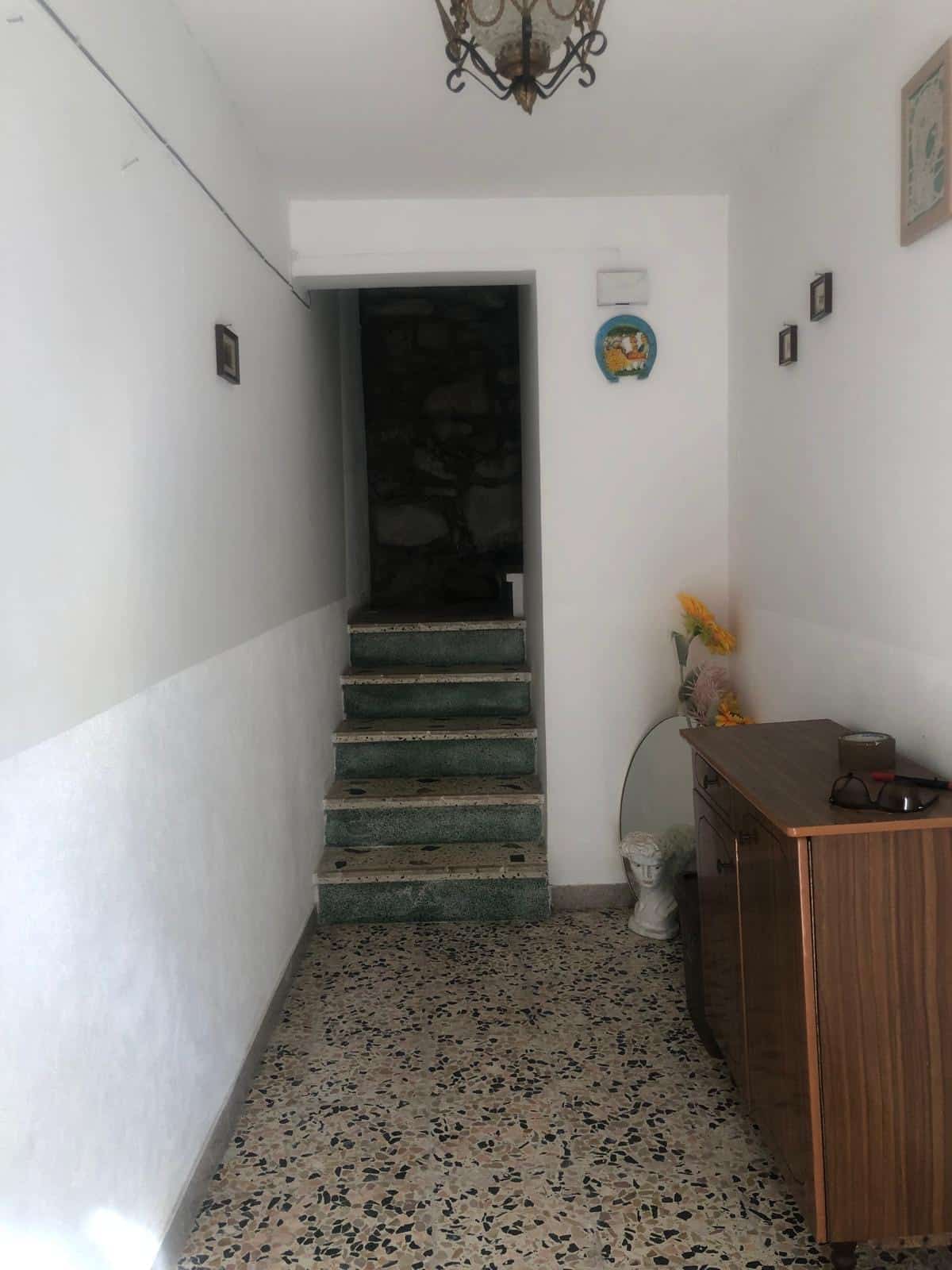Entrata di casa con scale in marmo verde e ingresso arredato con mobili classici, decorazioni e fiori, ambienti luminosi e accoglienti - ideale per chi cerca soluzioni abitative funzionali e di stile.