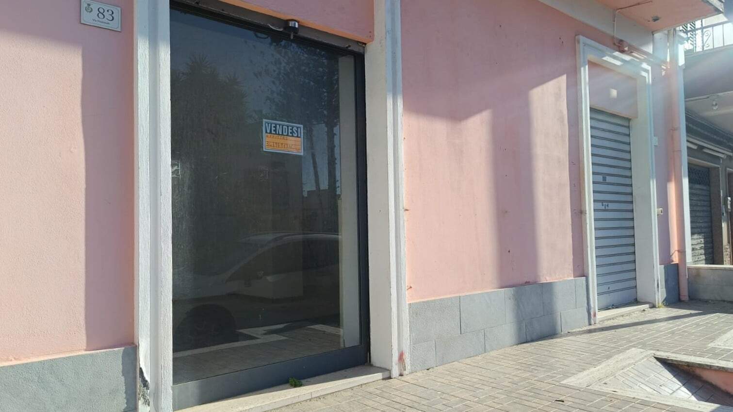Vetrina commerciale in vendita con segnale "VENDESI" presso NextCasa, negozio in zona centrale. Perfetta opportunità per attività o investimento immobiliare. Adatta a diverse esigenze di business.