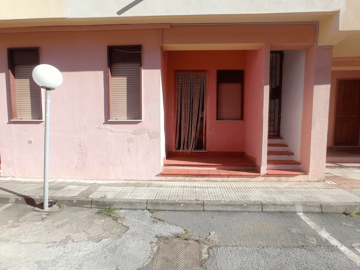 Facciata di un appartamento in vendita in via Stazione 90, Oliveri, con ingresso e finestre.