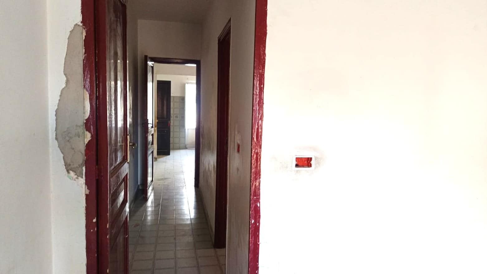 Porta in legno in fase di ristrutturazione con pareti interne in costruzione, ambiente abitativo da rinnovare, dettaglio di lavori edilizi per ripristino e ristrutturazione casa, NextCasa.
