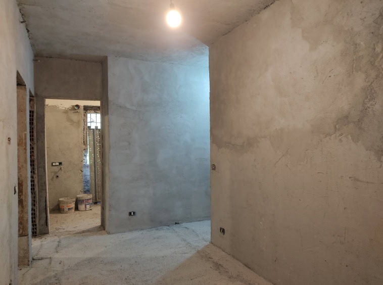 Impalcatura di un appartamento ancora in fase di ristrutturazione, pareti e pavimenti in calcestruzzo, pronti per finiture interne.
