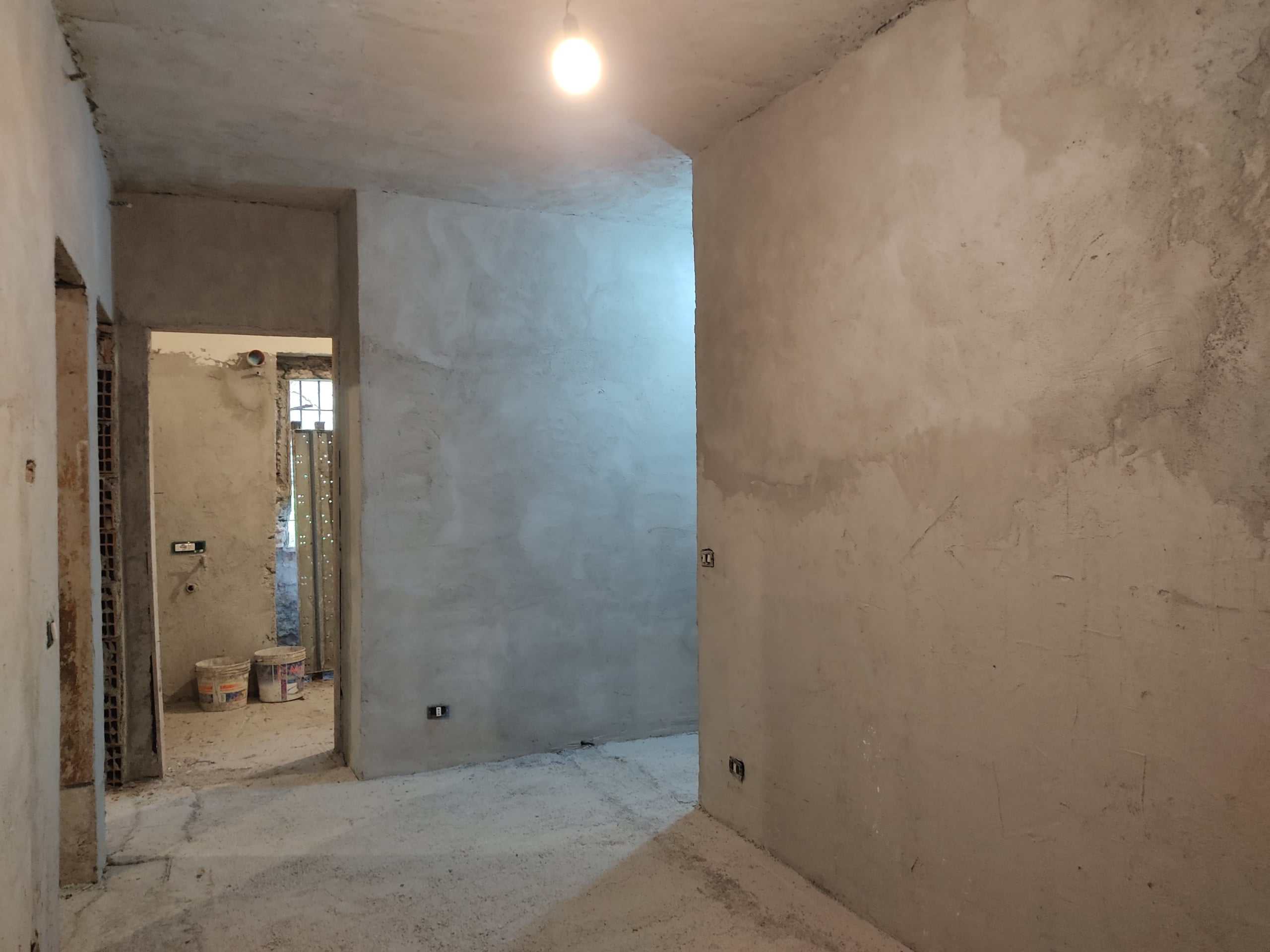 Impalcatura di un appartamento ancora in fase di ristrutturazione, pareti e pavimenti in calcestruzzo, pronti per finiture interne.