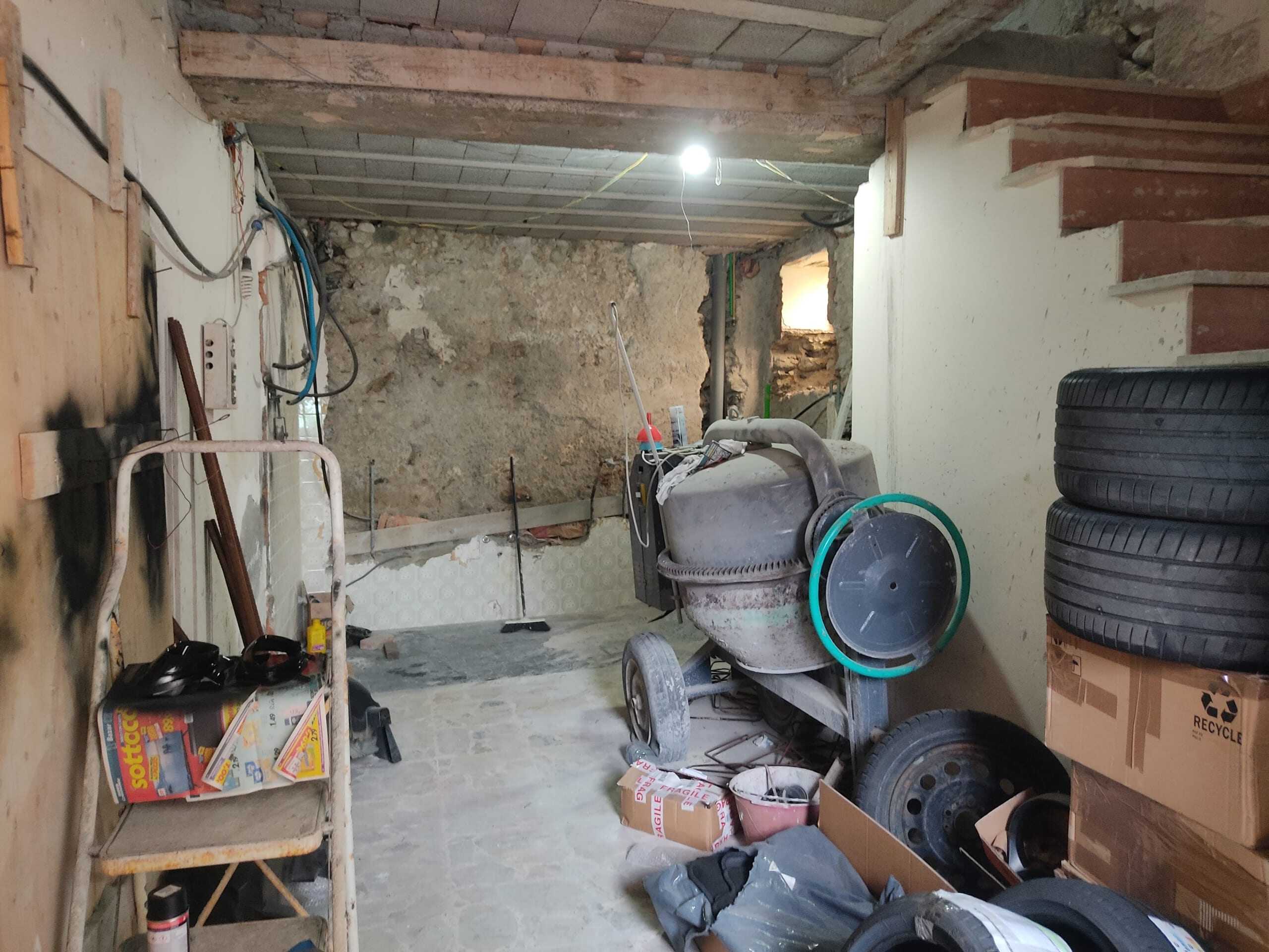 Valorizzazione di un ambiente in fase di ristrutturazione edilizia, con attrezzi da lavoro, pneumatici e materiali da costruzione. Immagine di uno spazio in fase di rinnovamento, pronto per trasformarsi in un ambiente abitabile.