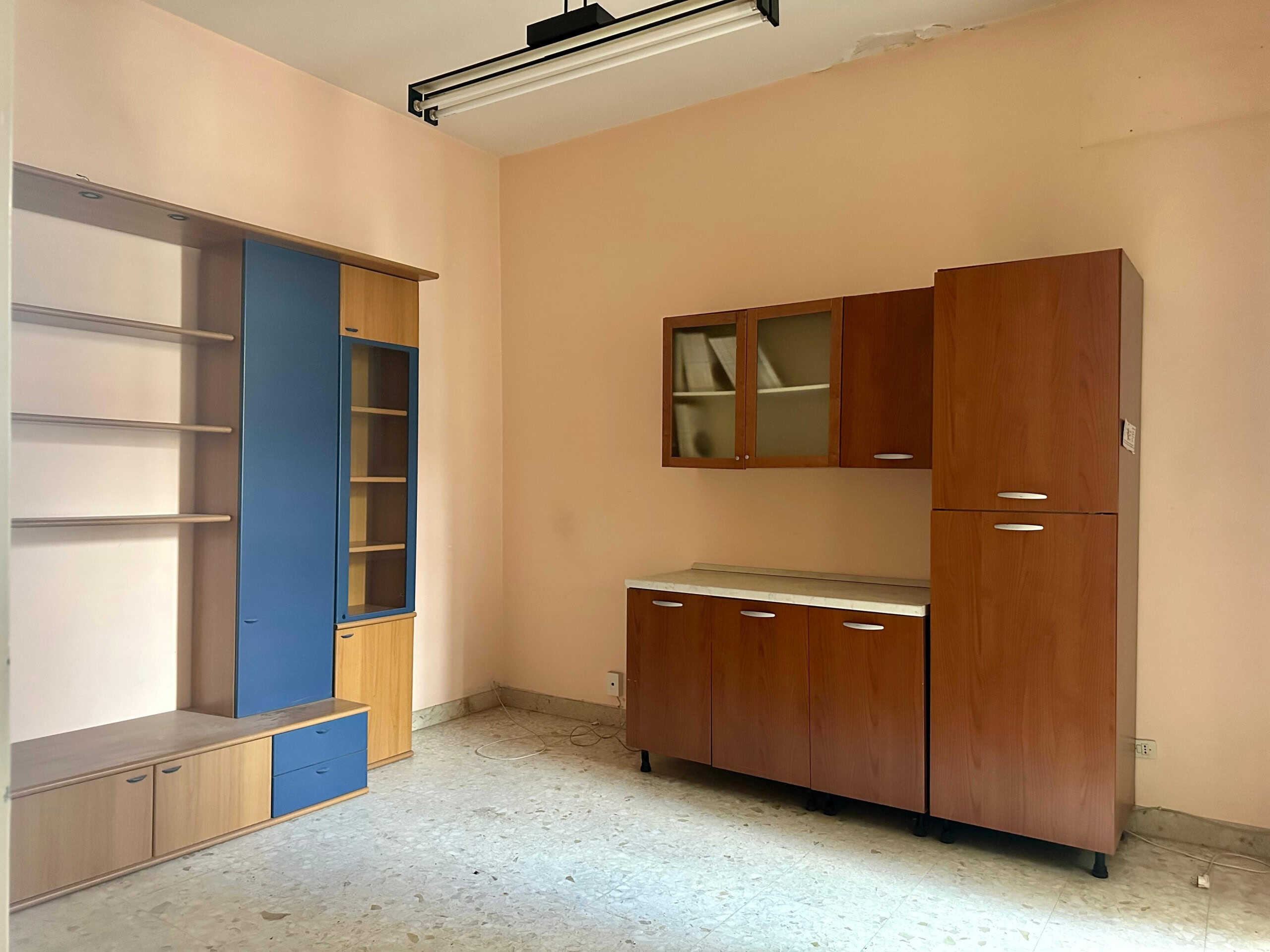 8f9b1707-0ef5-4c79-a911-c4bfa2ff5847 Mobili da cucina in stile vintage con armadi in legno e dettagli blu, spazio funzionale e luminoso.