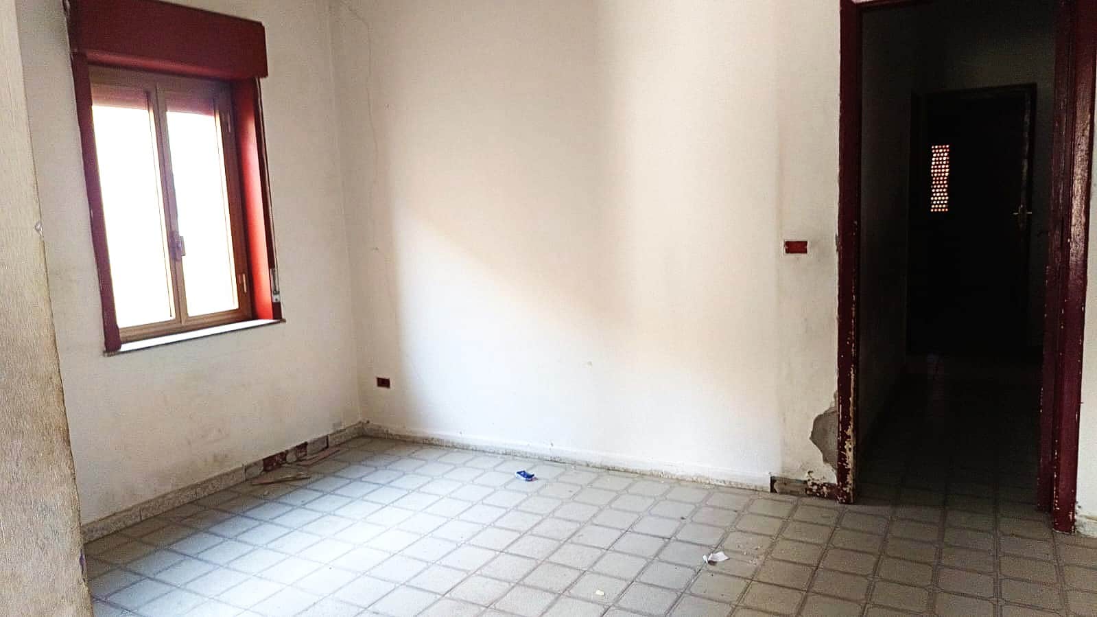 Finestra con curtains in una stanza vuota, pareti neutre e pavimento in piastrelle, spazio ideale per rinnovare e personalizzare la propria casa.