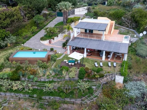 Casa con piscina nel verde, vista aerea, giardino curato e terrazza panoramica, ideale per relax e vita all'aperto, situata in zona tranquilla e naturale.