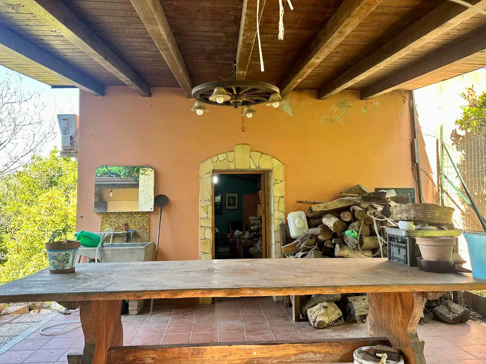 Fermacamera-karin ristorante rustico con tetto in legno, pietra e mattoni, ideale per outdoor e barbecue, arredamento autentico, vista su giardini e natura, perfetto per relax e convivialità.