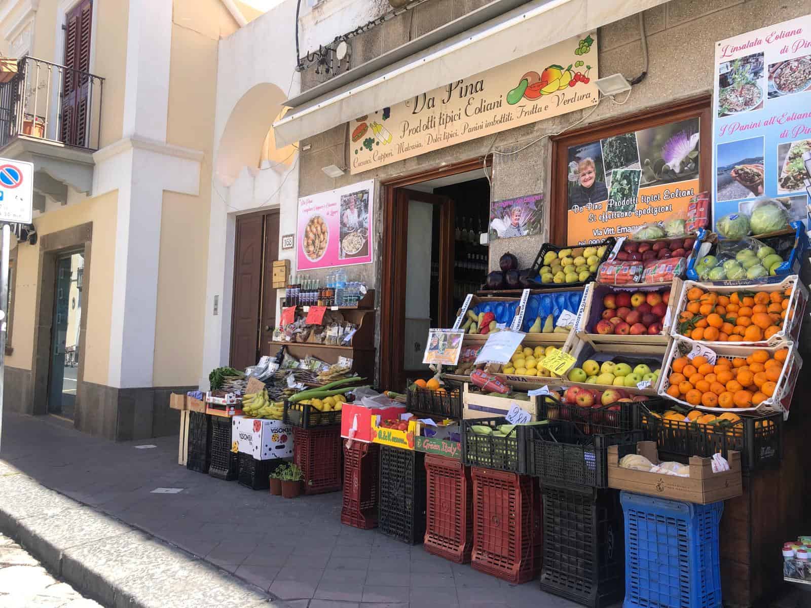 Pomodoro, mela e frutta fresca in negozio di prodotti tipici locali a strada principale.