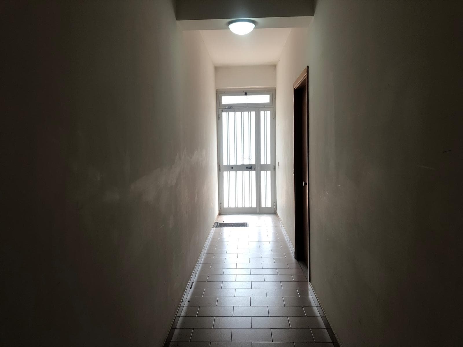 Ingresso condominiale con porta blindata e pavimentazione in piastrelle; spazio luminoso e sicuro, ideale per accogliere residenti e visitatori.
