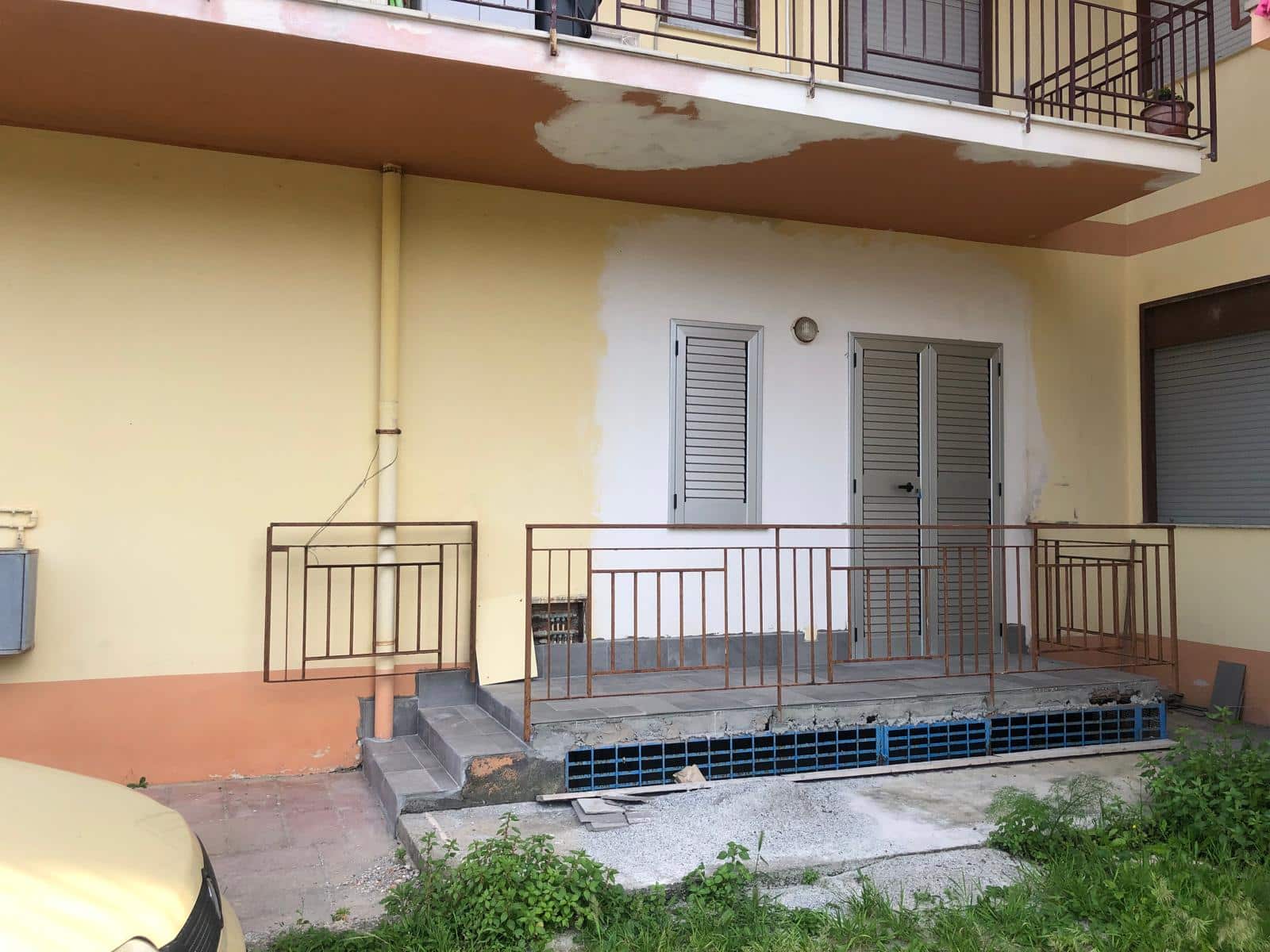 Ricostruzione portico condominiale con ringhiera in ferro, lavori di ristrutturazione esterno appartamento, edilizia residenziale, intervento di restauro abitativo, NextCasa edilizia Milano.