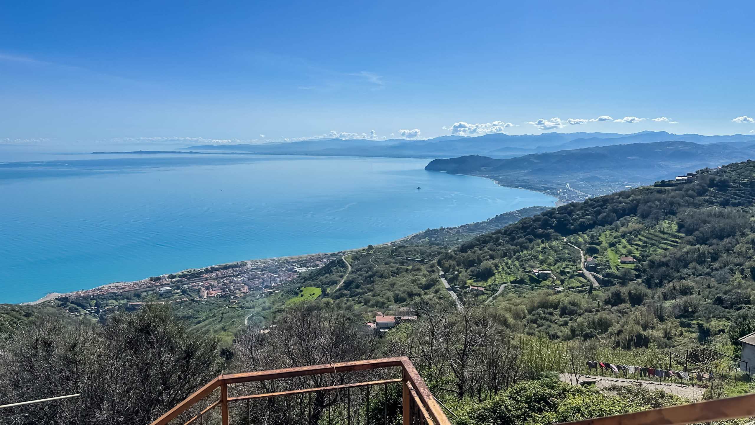 Vista panoramica sul lago di Como e sulle colline circostanti, con case e terreni agricoli immersi nella natura, ideale per immobili di lusso e investimenti immobiliari.