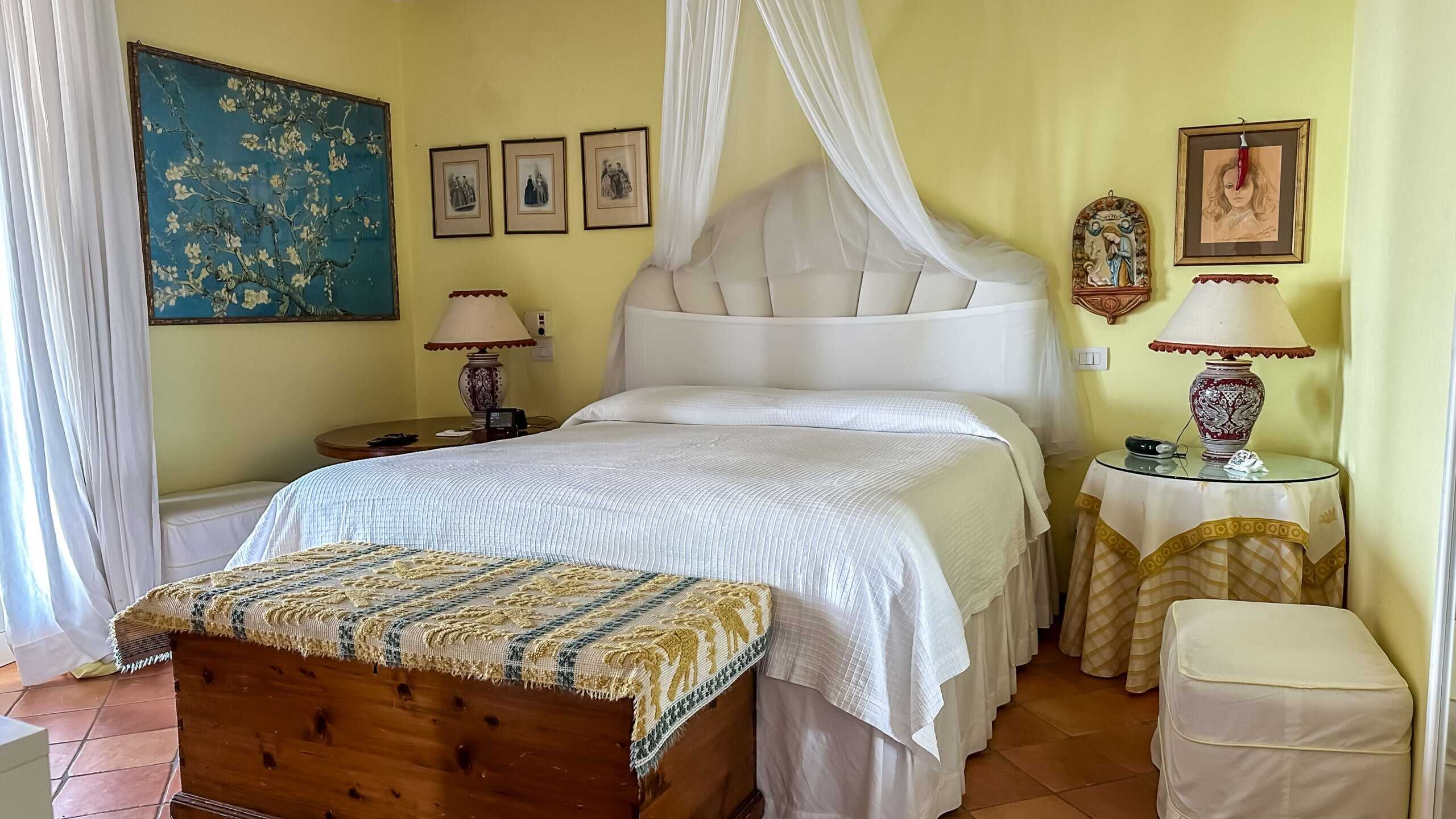 Letto matrimoniale vista interna in stile classico con lampade da tavolo e decorazioni artistiche.
