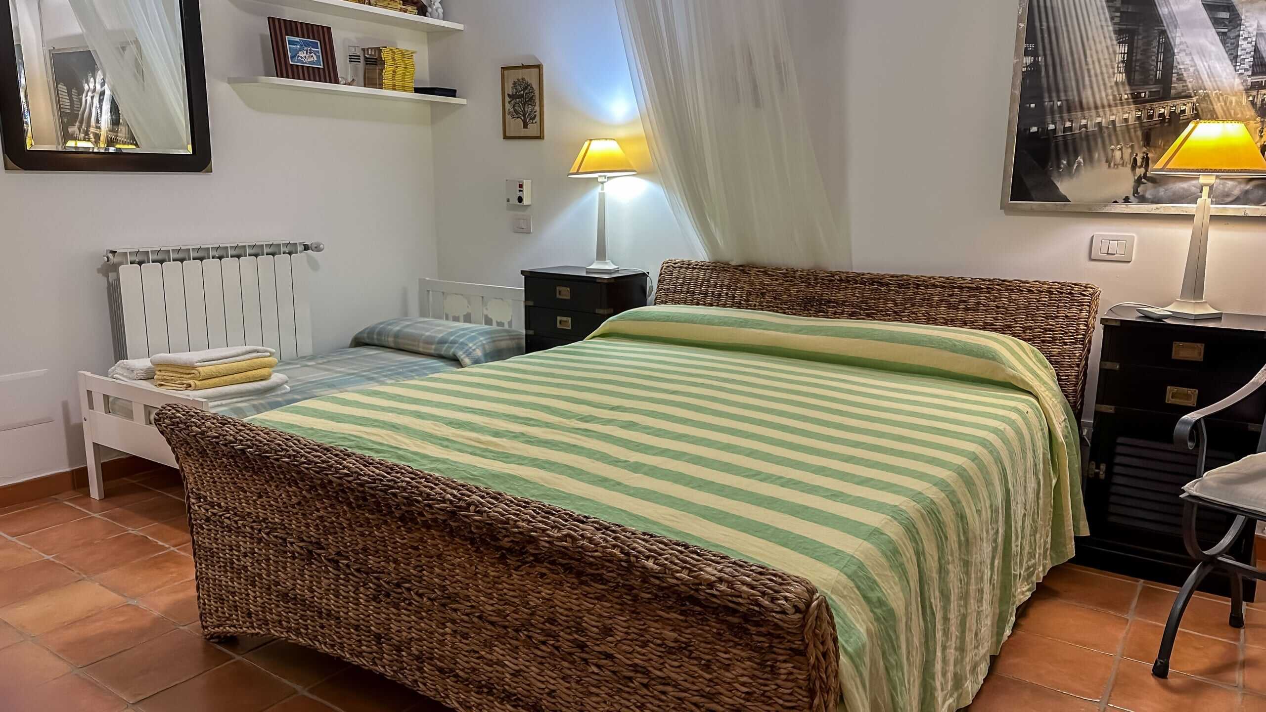 Lenzuola e cuscini su letto in camera da letto con arredamento accogliente e lampade da tavolo.