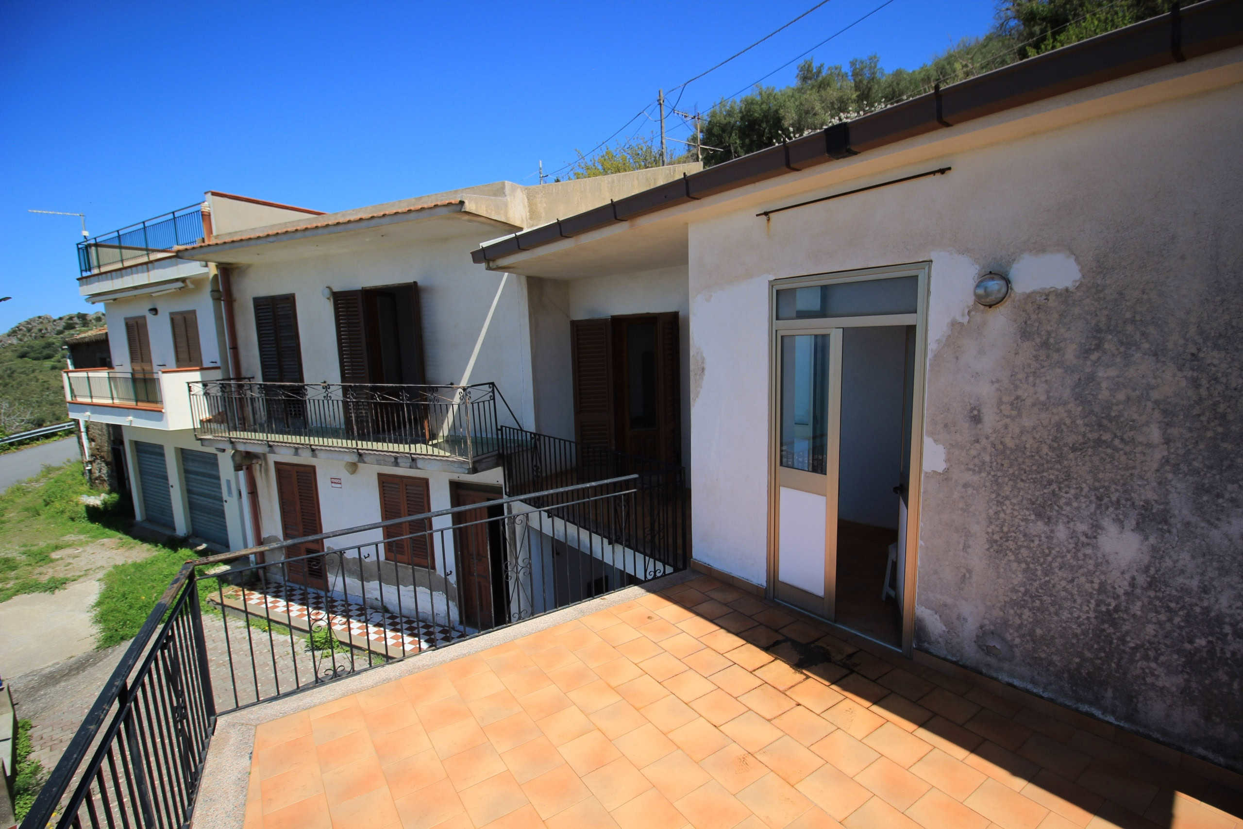Balcone di appartamento in stile mediterraneo con vista sulle colline, progettato per affitti e vendite di immobili a NextCasa, agenzia immobiliare esperta in proprietà in località turistiche italiane.