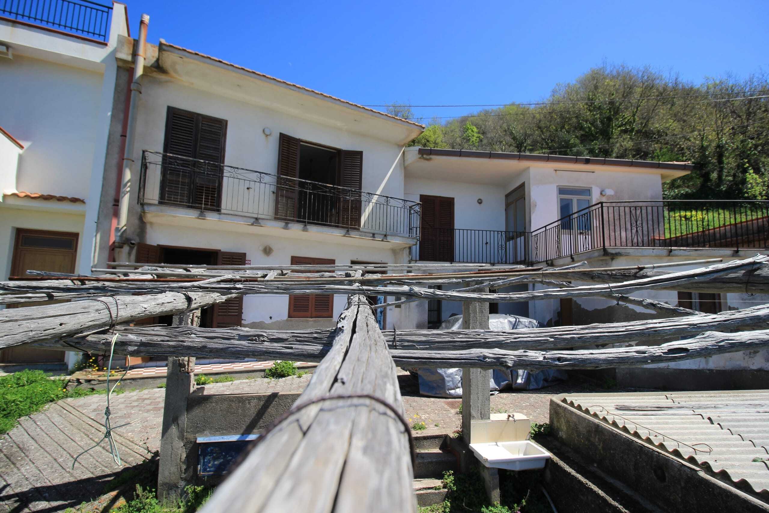 Stabile casa bifamiliare con balcone e terrazza, situata in un'area tranquilla immersa nel verde, ideale per acquisti immobiliari e investimento immobiliare in Italia.
