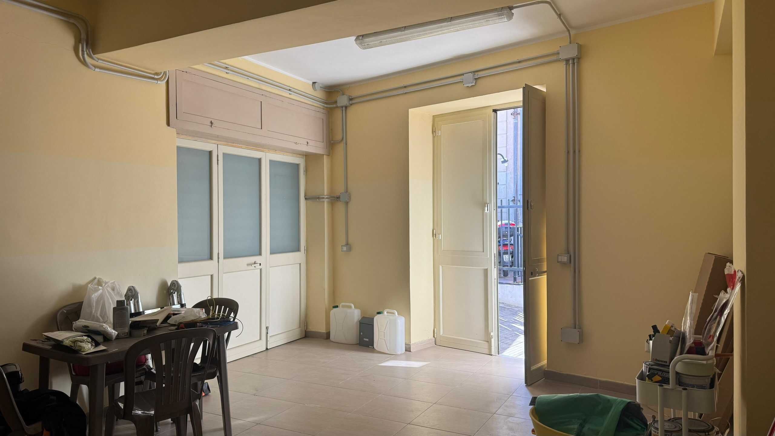 Immagine di un appartamento con pareti color crema, porta d'ingresso aperta e ingresso luminoso, ideale per annunci immobiliari e promozione di vendita o affitto case.