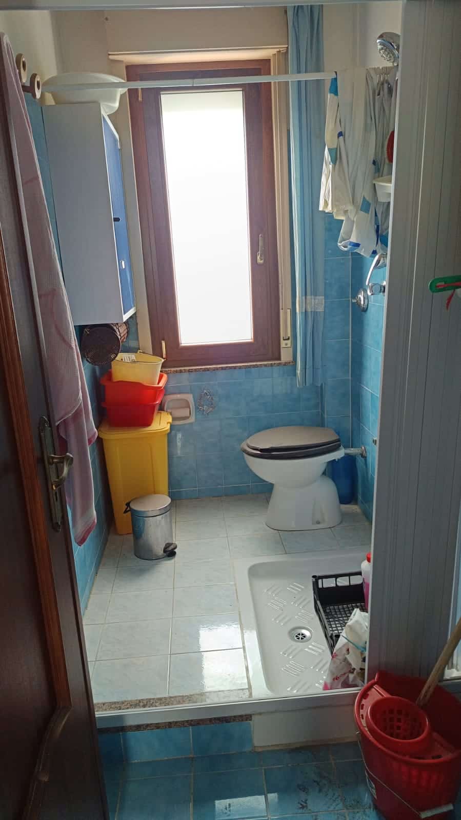 Lavabo bagno con finestra e cabina doccia, ambientazione funzionale e pratico per l'uso quotidiano.