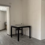 Arredo moderno appartamento NextCasa, spazio abitativo con soggiorno e angolo cottura, pavimenti in gres, arredi funzionali, atmosfera luminosa, ideale per vivere in comfort e stile.