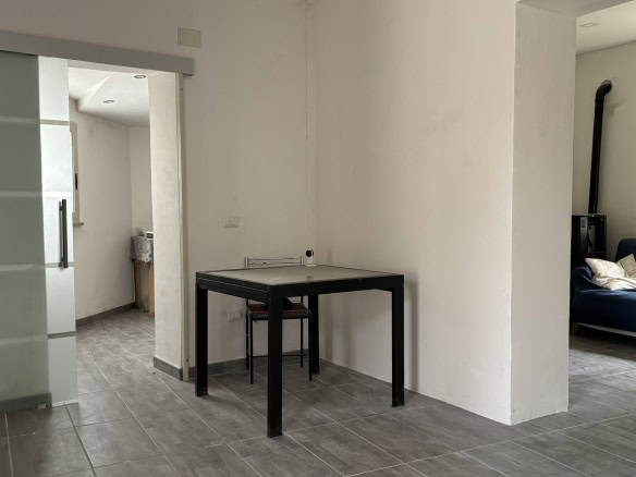 Arredo moderno appartamento NextCasa, spazio abitativo con soggiorno e angolo cottura, pavimenti in gres, arredi funzionali, atmosfera luminosa, ideale per vivere in comfort e stile.
